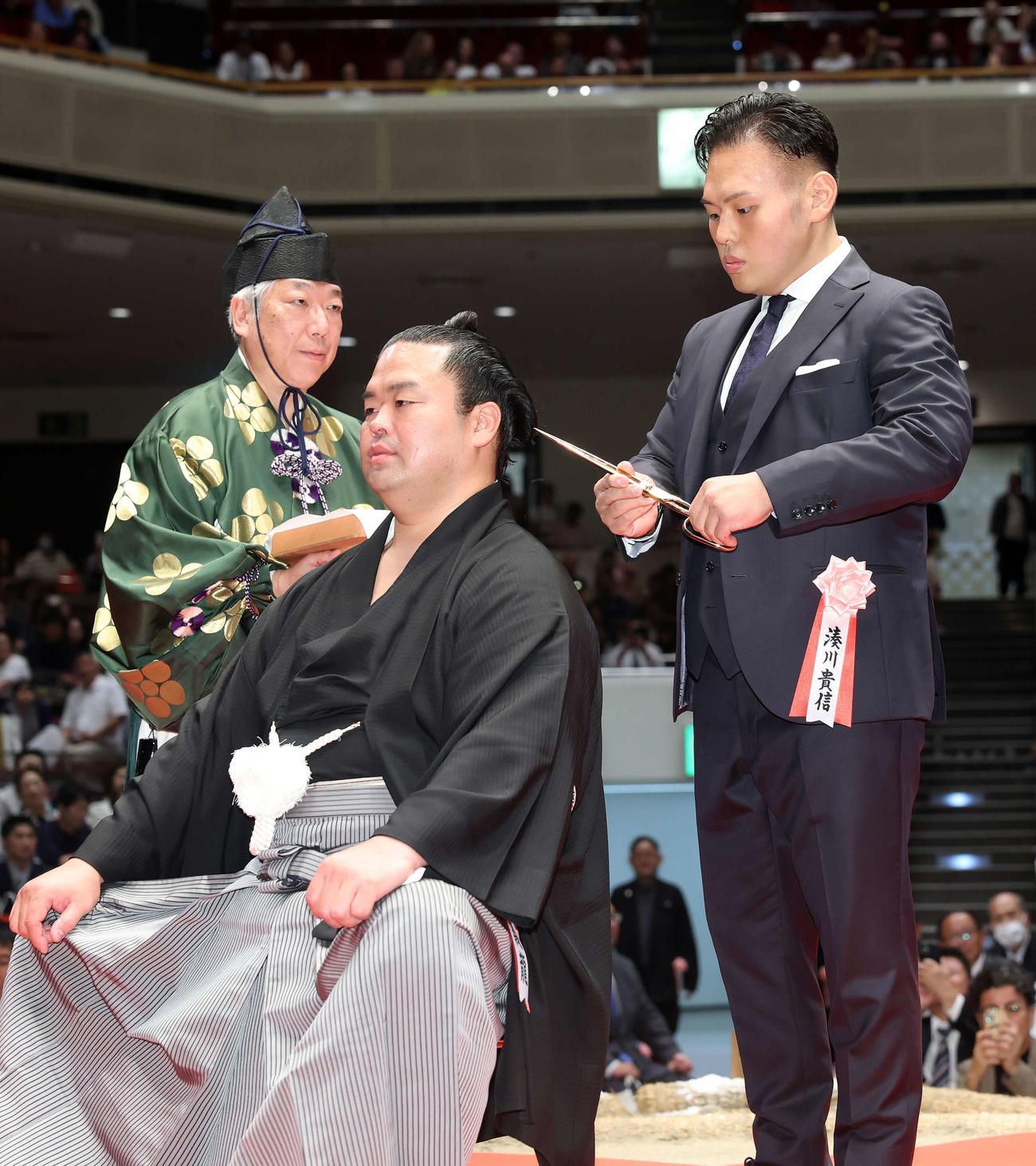 湊川親方（右）にはさみを入れてもらう振分親方（撮影・鈴木正人）