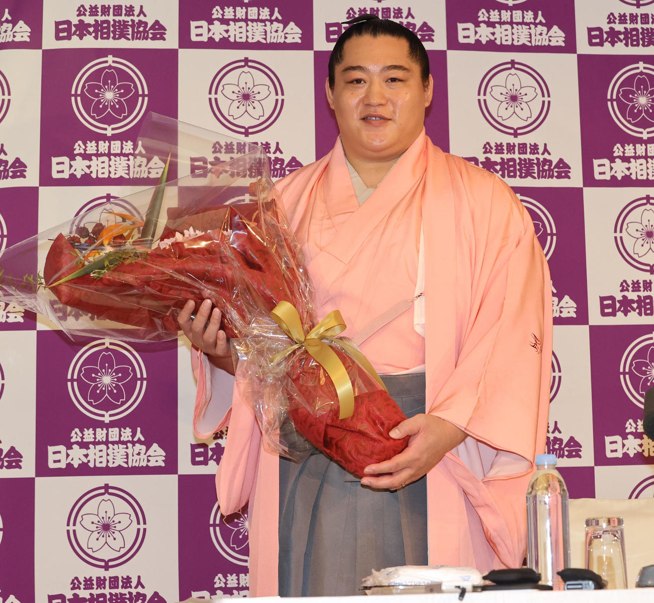 現役引退を決め、年寄「北陣」を襲名した元小結遠藤の北陣親方は花束を手に笑顔（撮影・梅根麻紀）