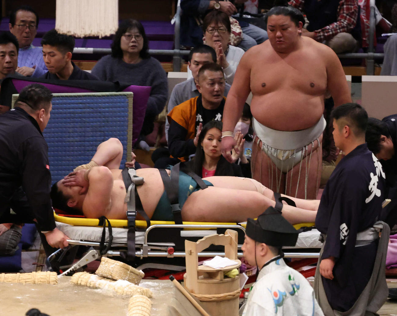 十両の三田（右）は輝に浴びせ倒しで敗れ土俵に座り込んだがしばらくして寝転び、担架からストレッチャーに移され退場（2025年11月10日）