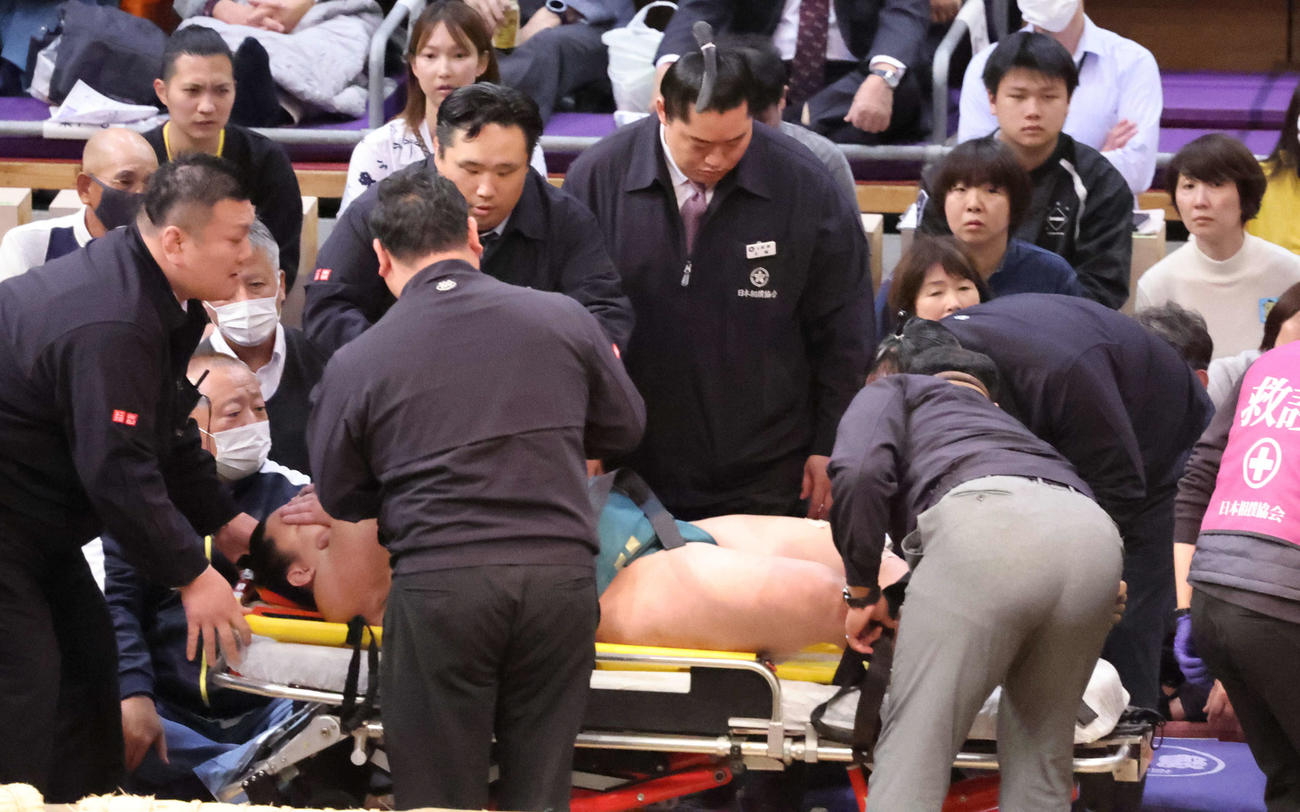 十両の三田（右）は輝に浴びせ倒しで敗れ土俵に座り込んだがしばらくして寝転び、担架からストレッチャーに移される（2025年11月10日）