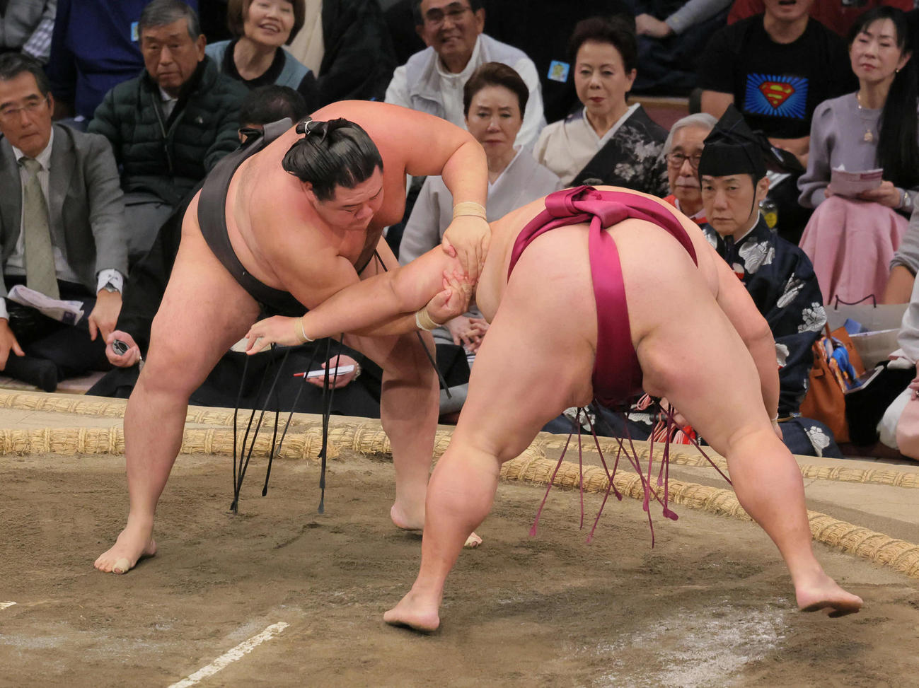 明生（左）は御嶽海を肩すかしで破る（撮影・宮崎幸一）