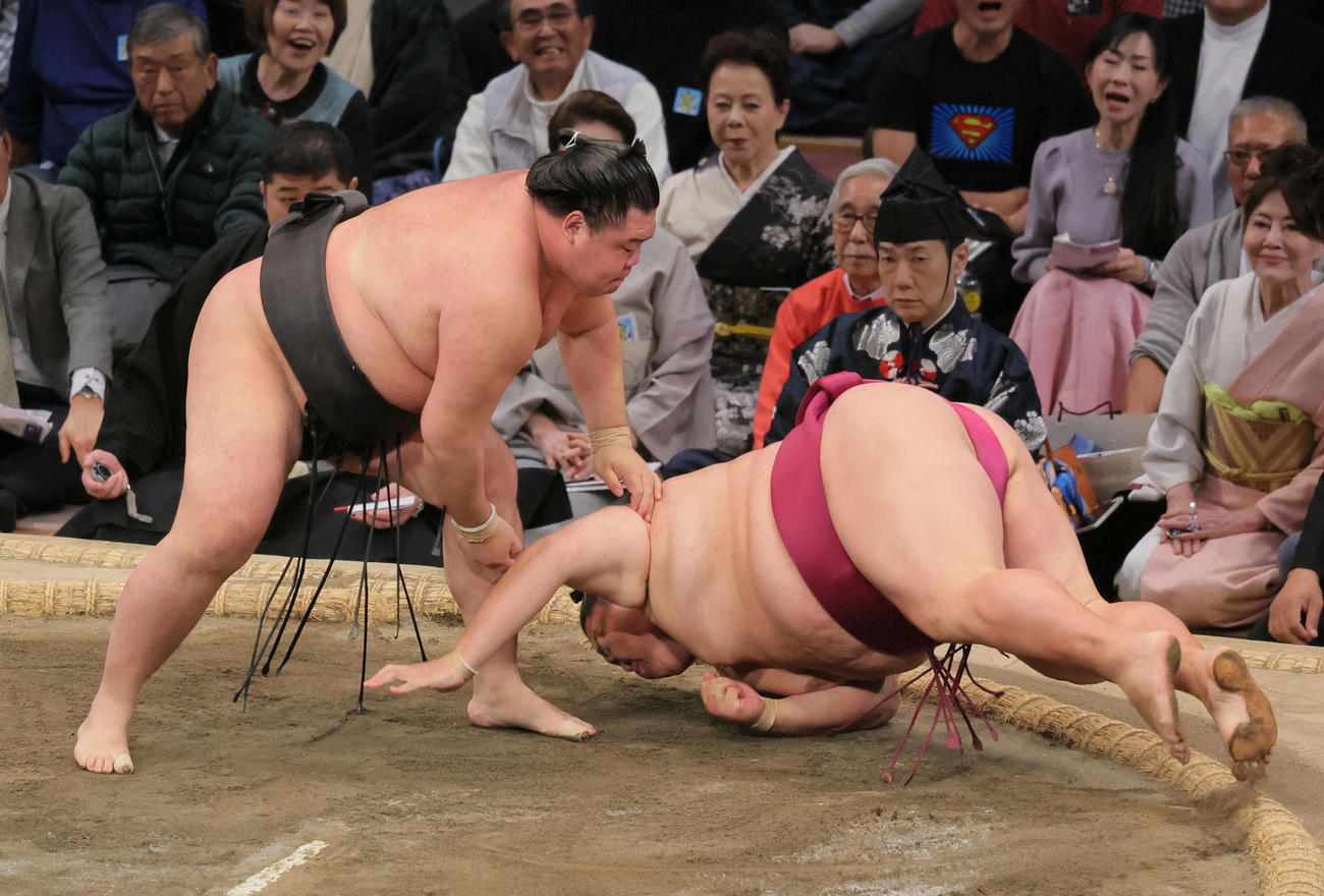 明生（左）は御嶽海を肩すかしで破る（撮影・宮崎幸一）