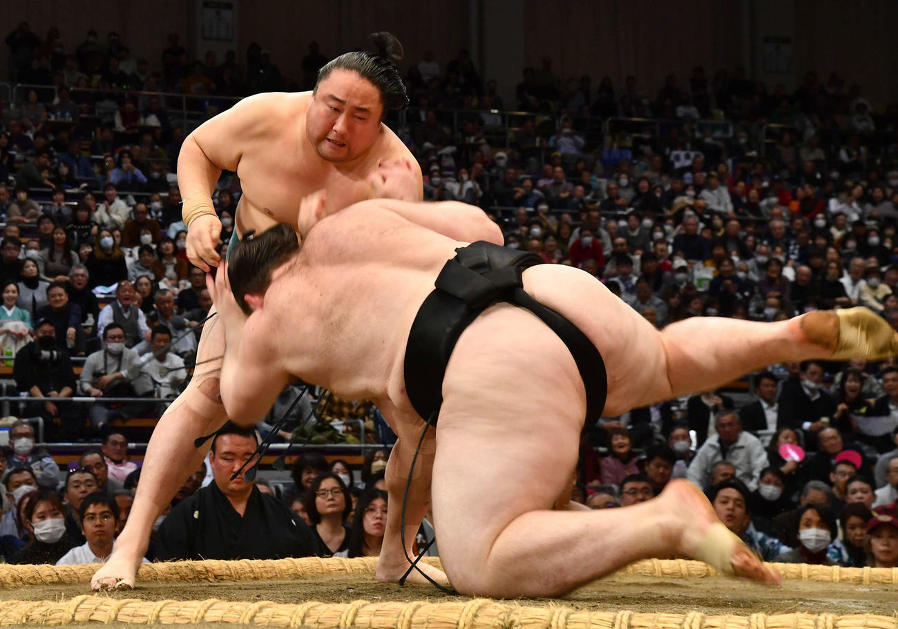 佐田の海（左）は獅司を首ひねりで破る（撮影・岩下翔太）