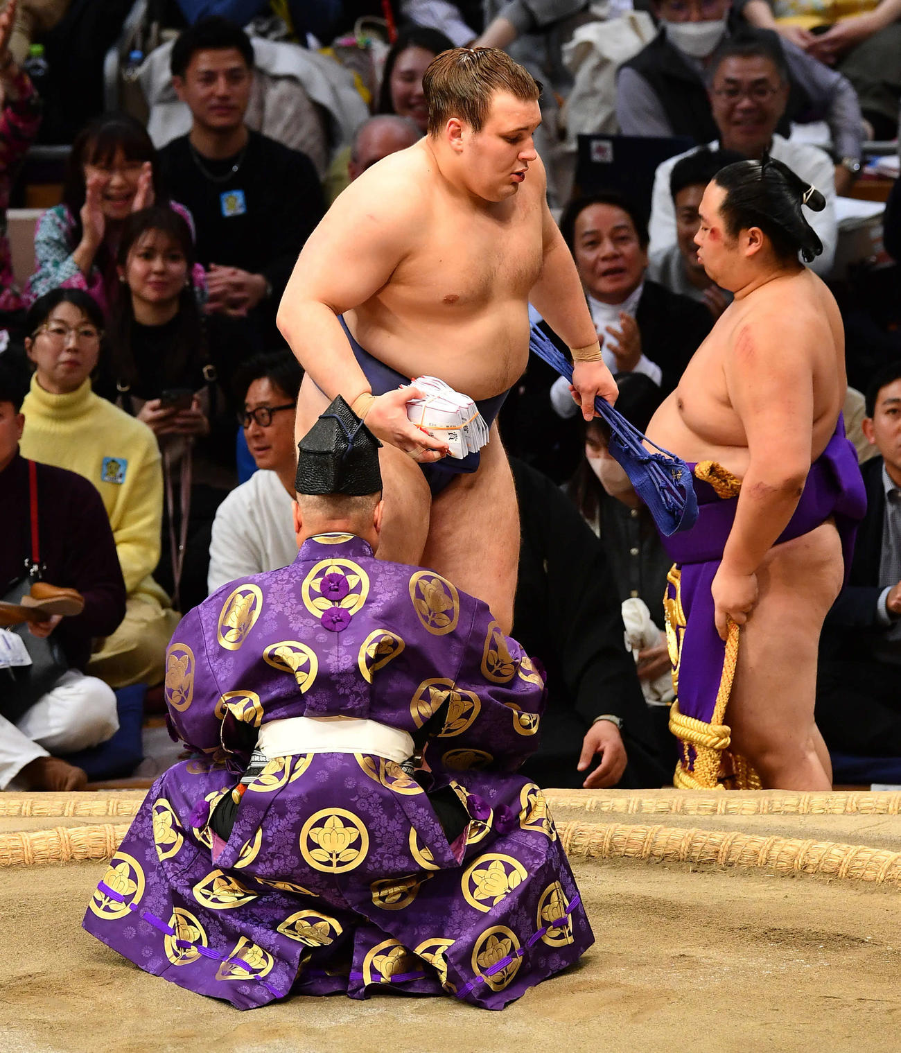 押し出しで豊昇龍を破り、懸賞金の束を手に土俵を降りる安青錦（撮影・岩下翔太）