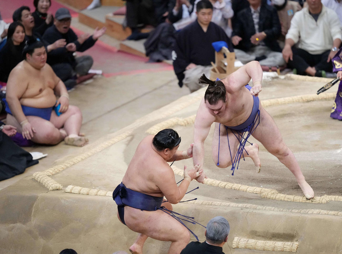 安青錦（右）は豊昇龍を押し出しで破る。左奥は土俵下控えの大の里（撮影・小沢裕）