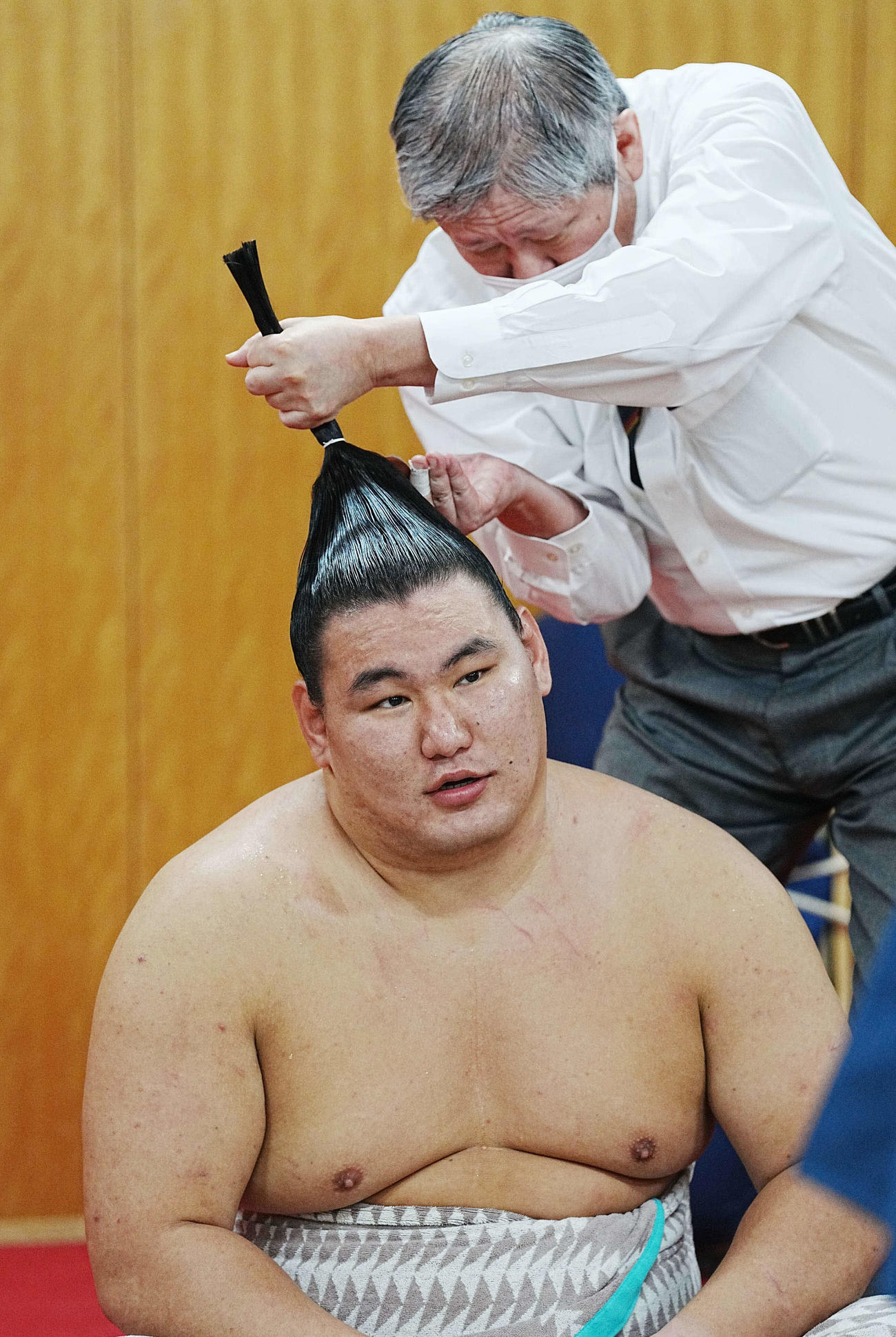 支度部屋で髪を整えてもらう豊昇龍（撮影・小沢裕）