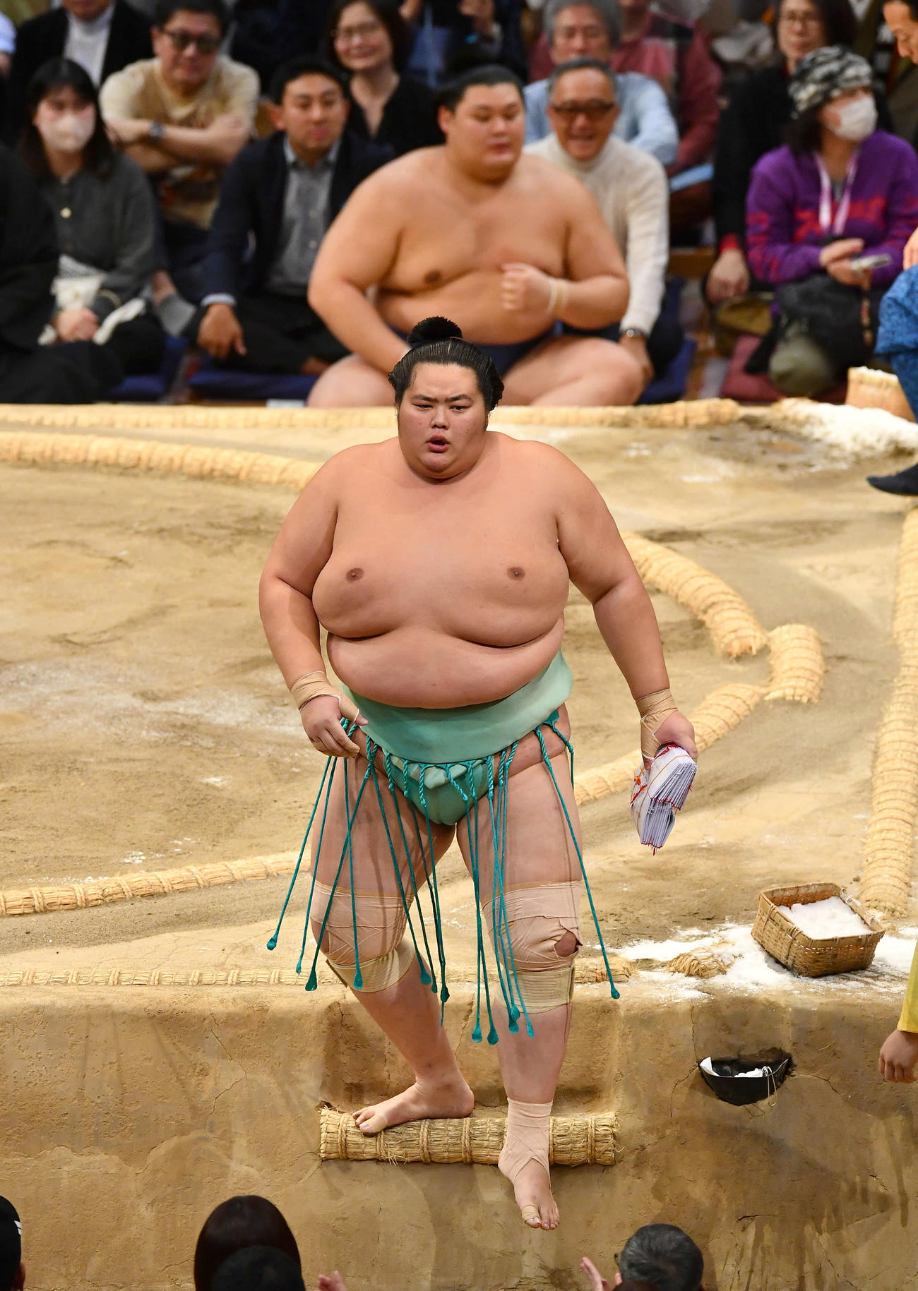 寄り切りで大の里（奥）を破り、懸賞金の束を手に土俵を降りる琴桜（撮影・岩下翔太）