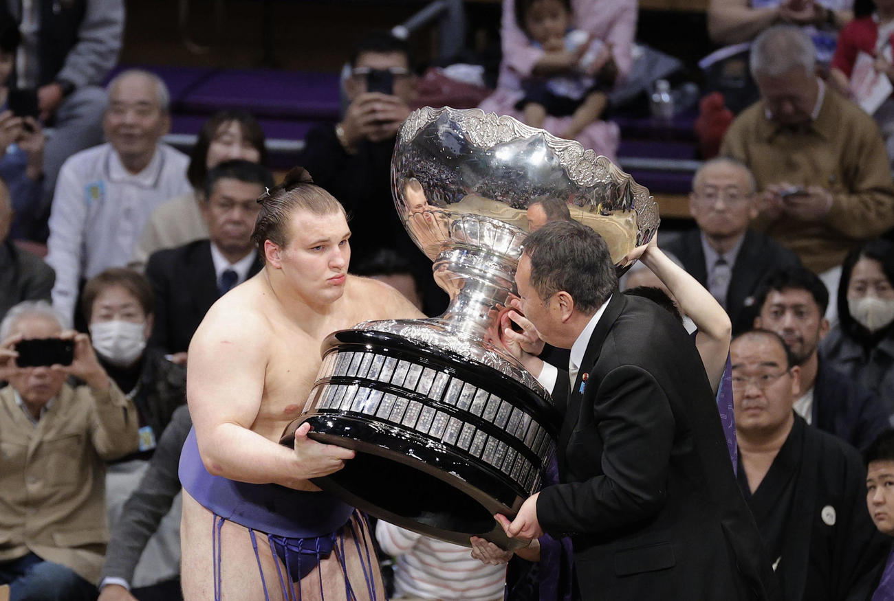 初優勝を果たし、内閣総理大臣杯を受け取る安青錦＝福岡国際センター(共同)