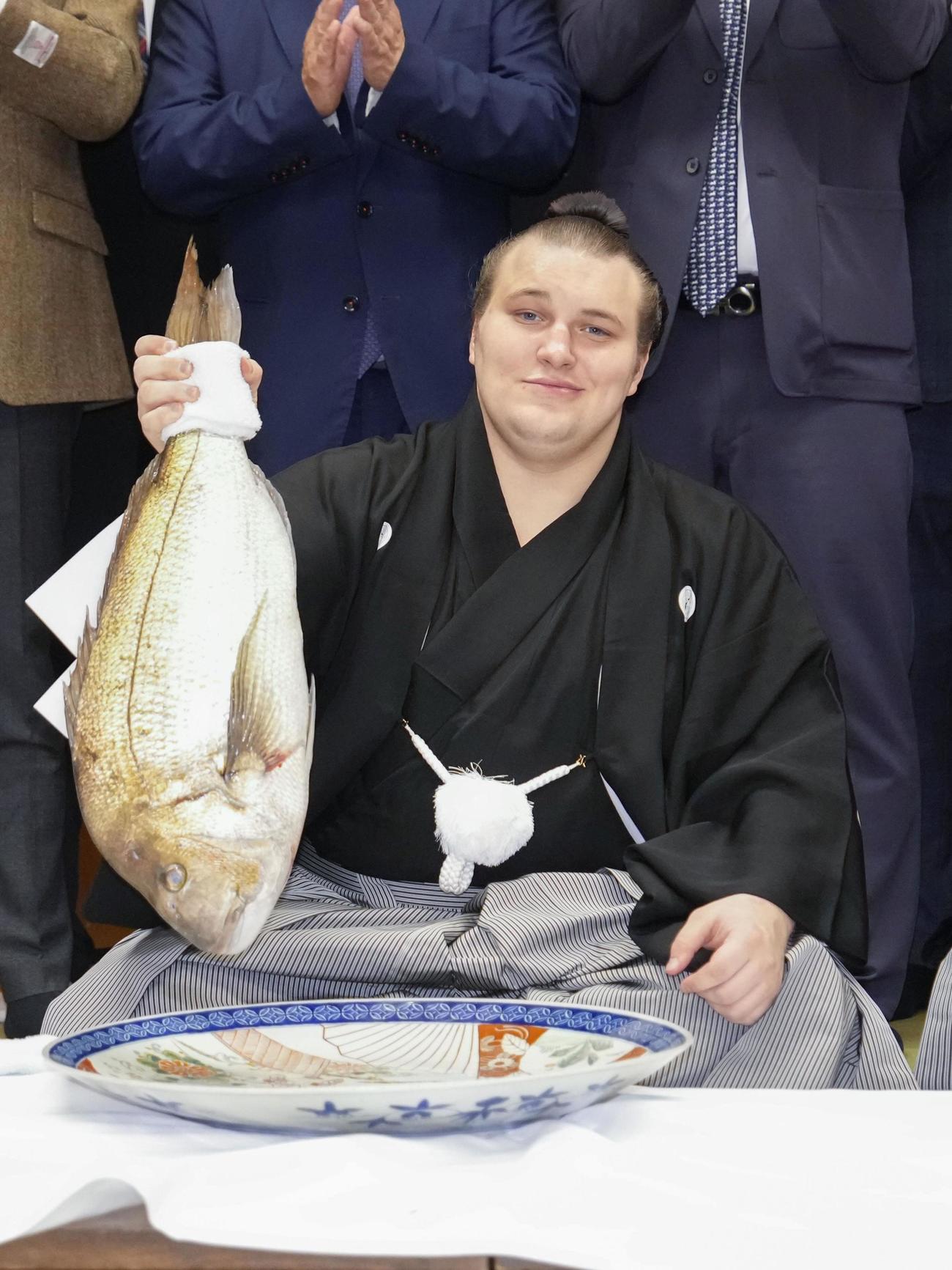 大相撲九州場所で初優勝を果たし、祝勝会でタイを手にする安青錦＝福岡県久留米市(共同)