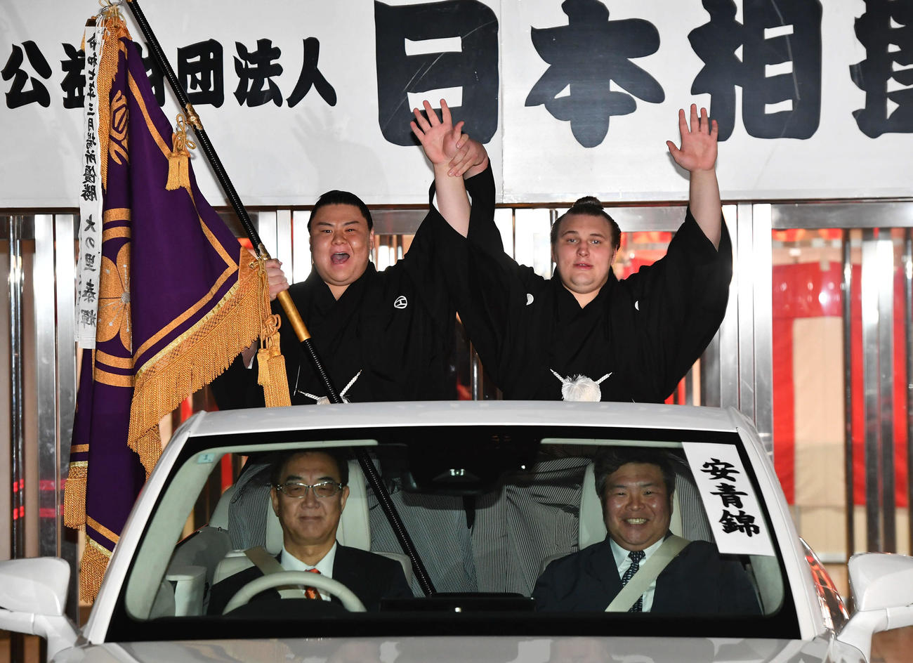 優勝パレードの出発前にばんざいする安青錦（右）。左は義ノ富士（撮影・岩下翔太）
