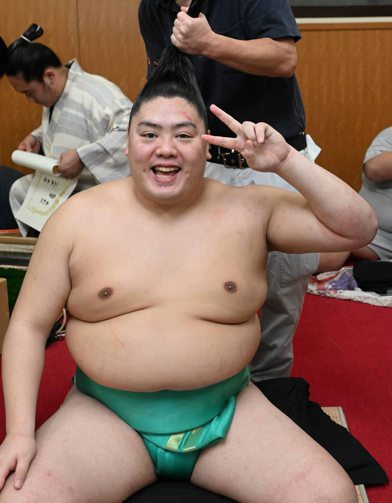 敢闘賞を受賞した一山本は支度部屋で笑顔でピース