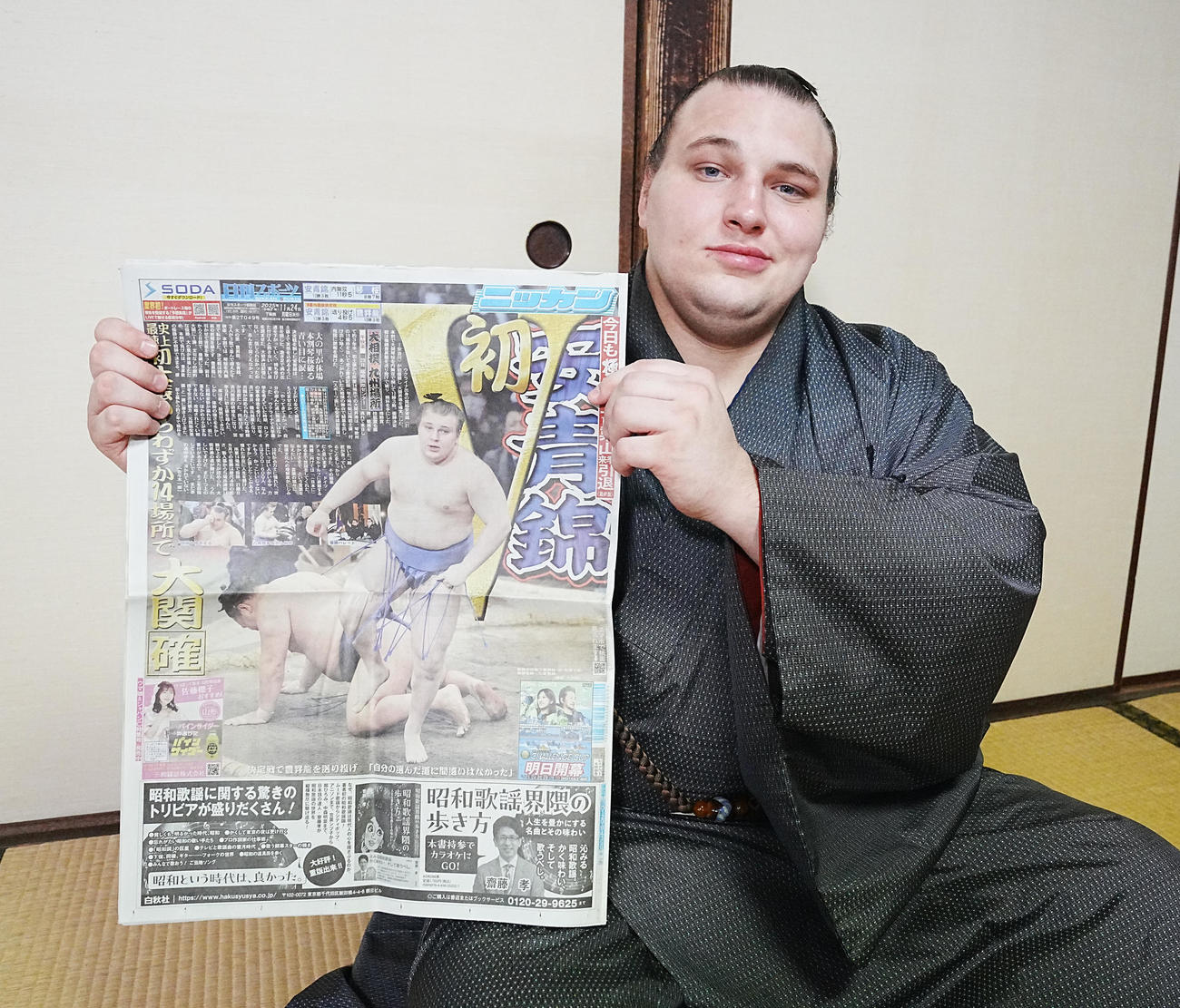 優勝一夜明け会見で本紙を手にする安青錦（撮影・小沢裕）