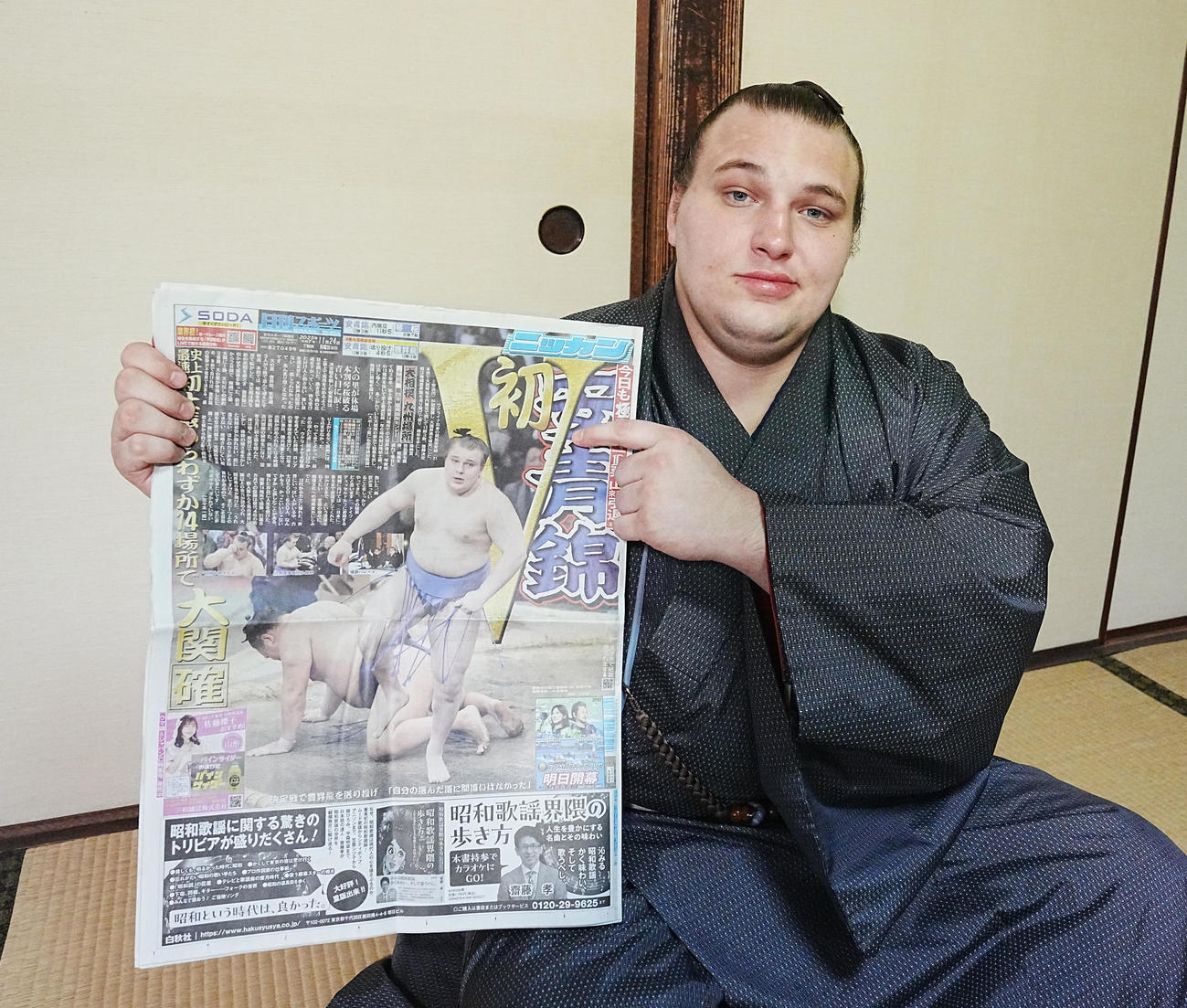 優勝一夜明け会見で本紙を手にする安青錦（撮影・小沢裕）