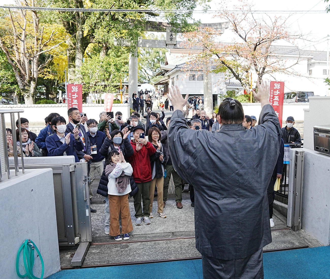 優勝一夜明け会見を終えた安青錦は詰め掛けた参拝客に手を振る（撮影・小沢裕）
