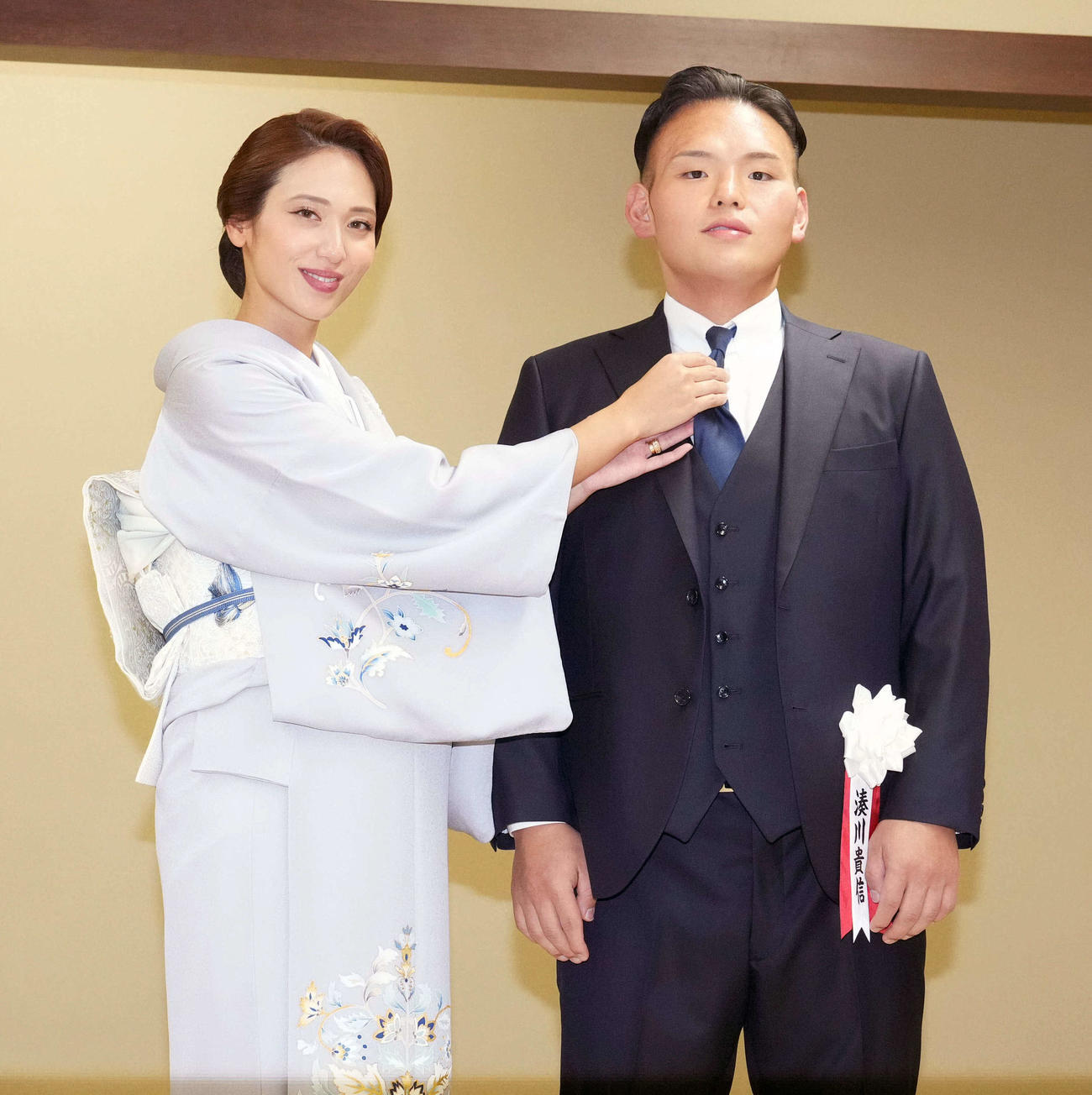 断髪後に整髪を終えた湊川親方は有希奈夫人（左）からネクタイを直してもらう（25年10月4日撮影）