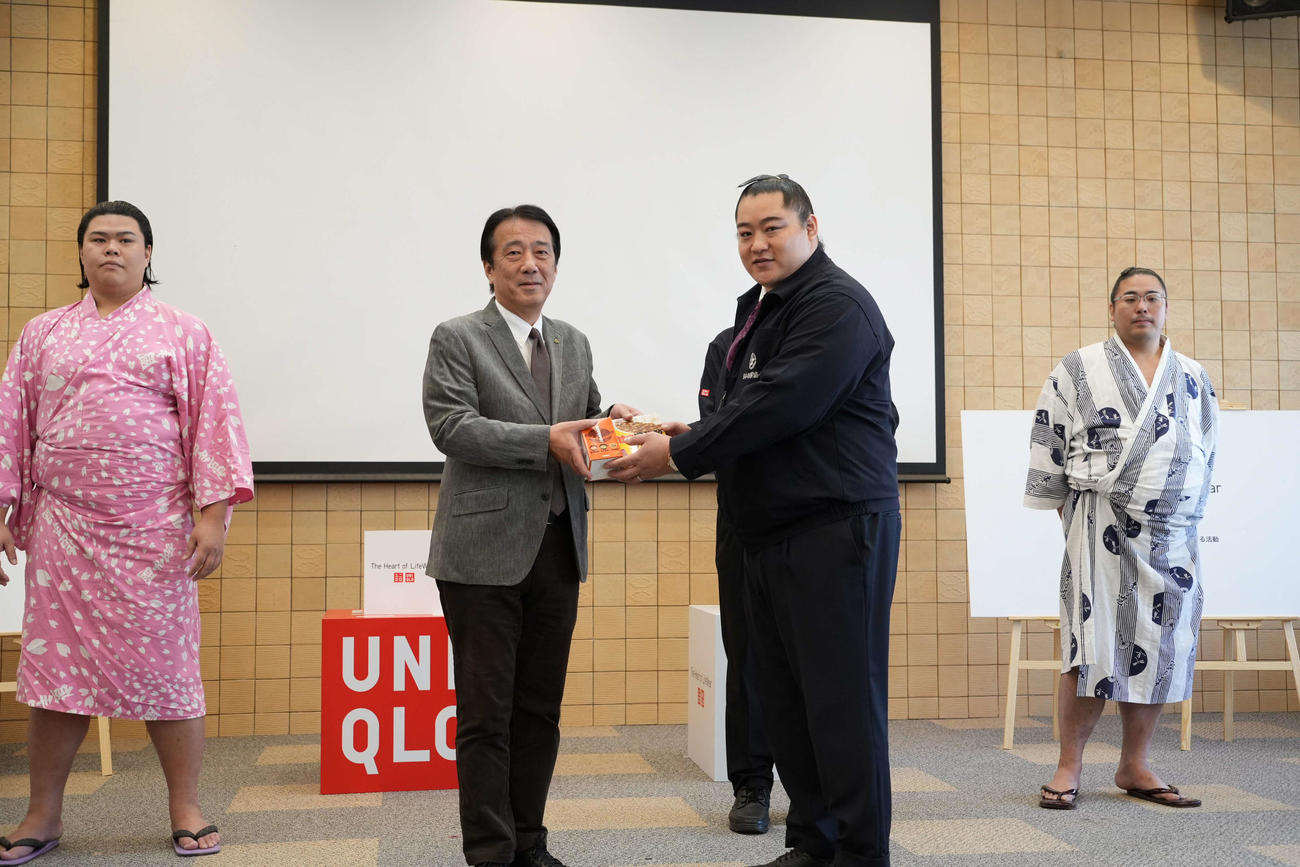 能美市の井出敏朗市長（左から2人目）に国技館カレーなどを手渡す北陣親方。左は可貴、右は栃登