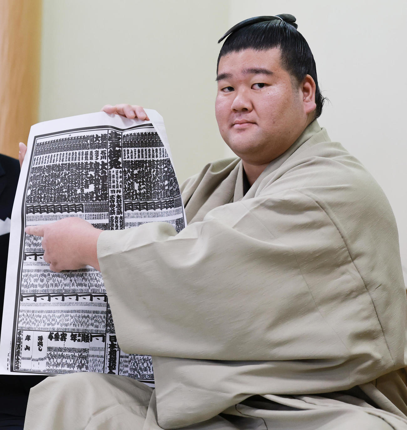 初場所での新入幕を決め、番付表を手にする羽出山（撮影・野上伸悟）