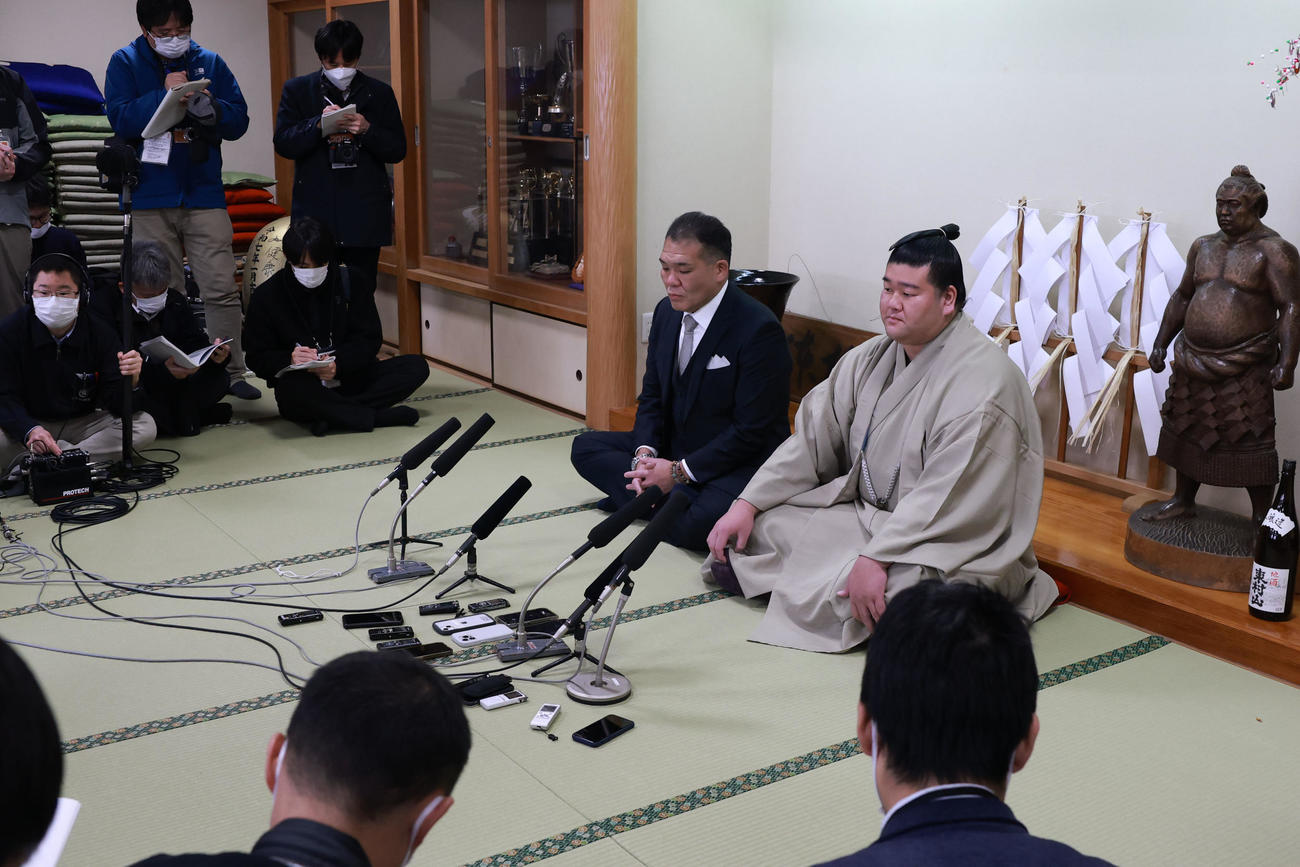 初場所での新入幕を決め、番付表を手にする羽出山。左は玉ノ井親方（撮影・野上伸悟）