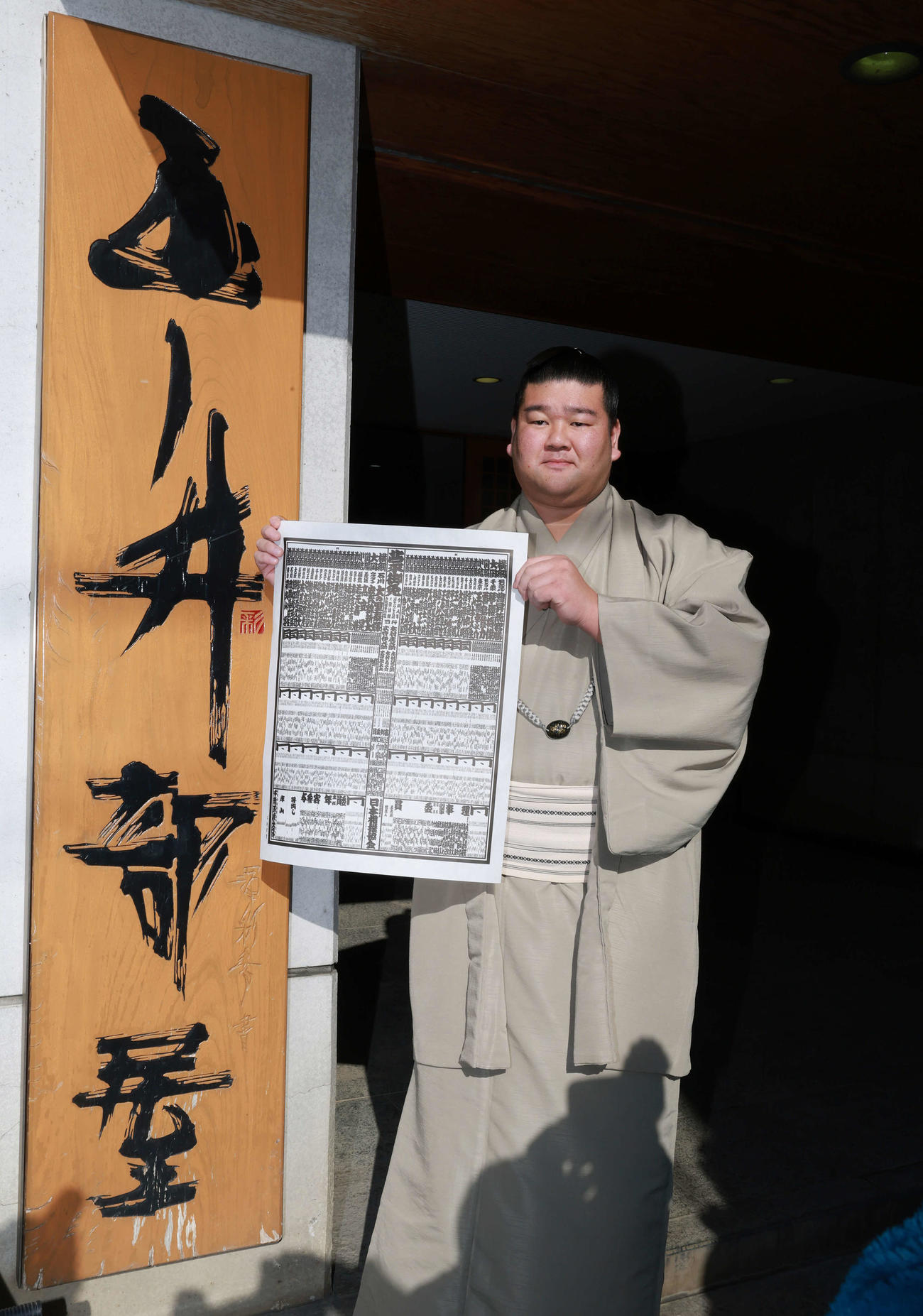 初場所での新入幕を決め、番付表を手にする羽出山（撮影・野上伸悟）