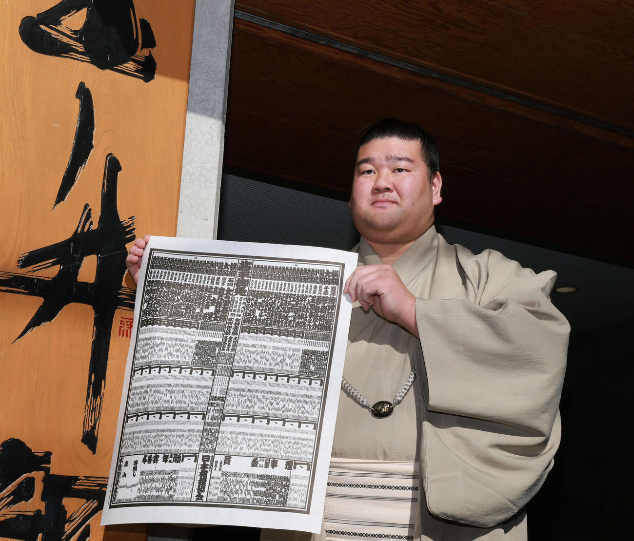 初場所での新入幕を決め、番付表を手にする羽出山（撮影・野上伸悟）