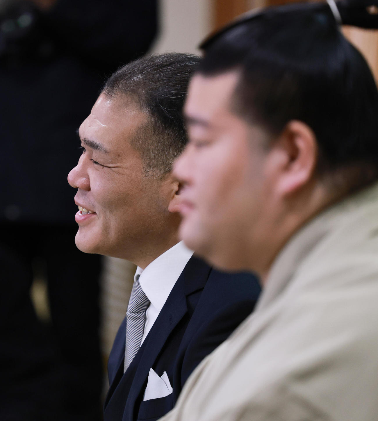羽出山（手前）が初場所での新入幕を決め、会見で笑顔をみせる玉ノ井親方（撮影・野上伸悟）