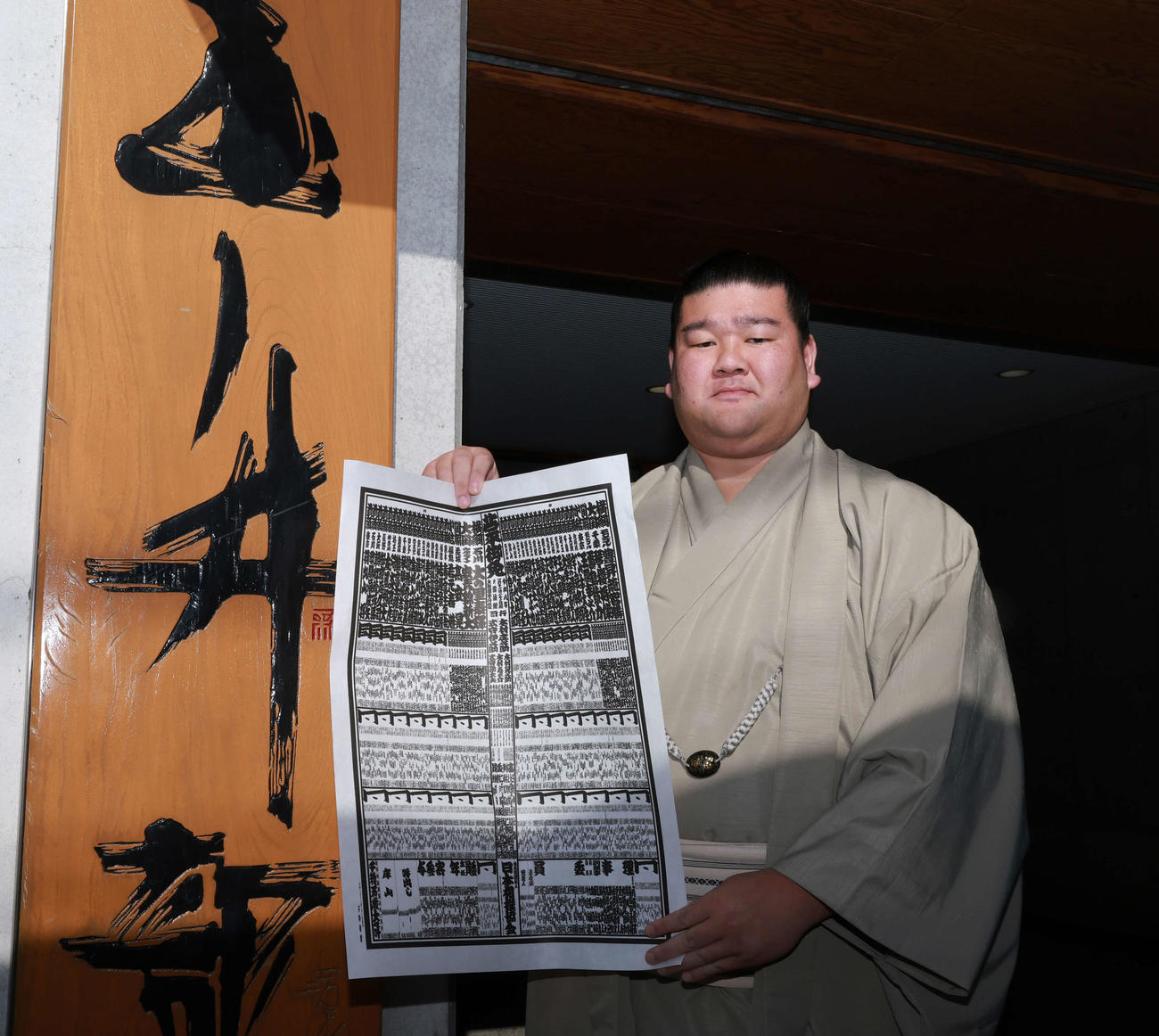 初場所での新入幕を決め、番付表を手にする羽出山（撮影・野上伸悟）