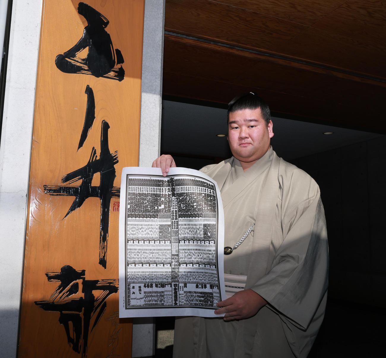 初場所での新入幕を決め、番付表を手にする羽出山（撮影・野上伸悟）