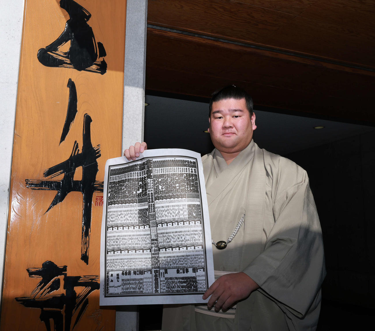 初場所での新入幕を決め、番付表を手にする羽出山（撮影・野上伸悟）