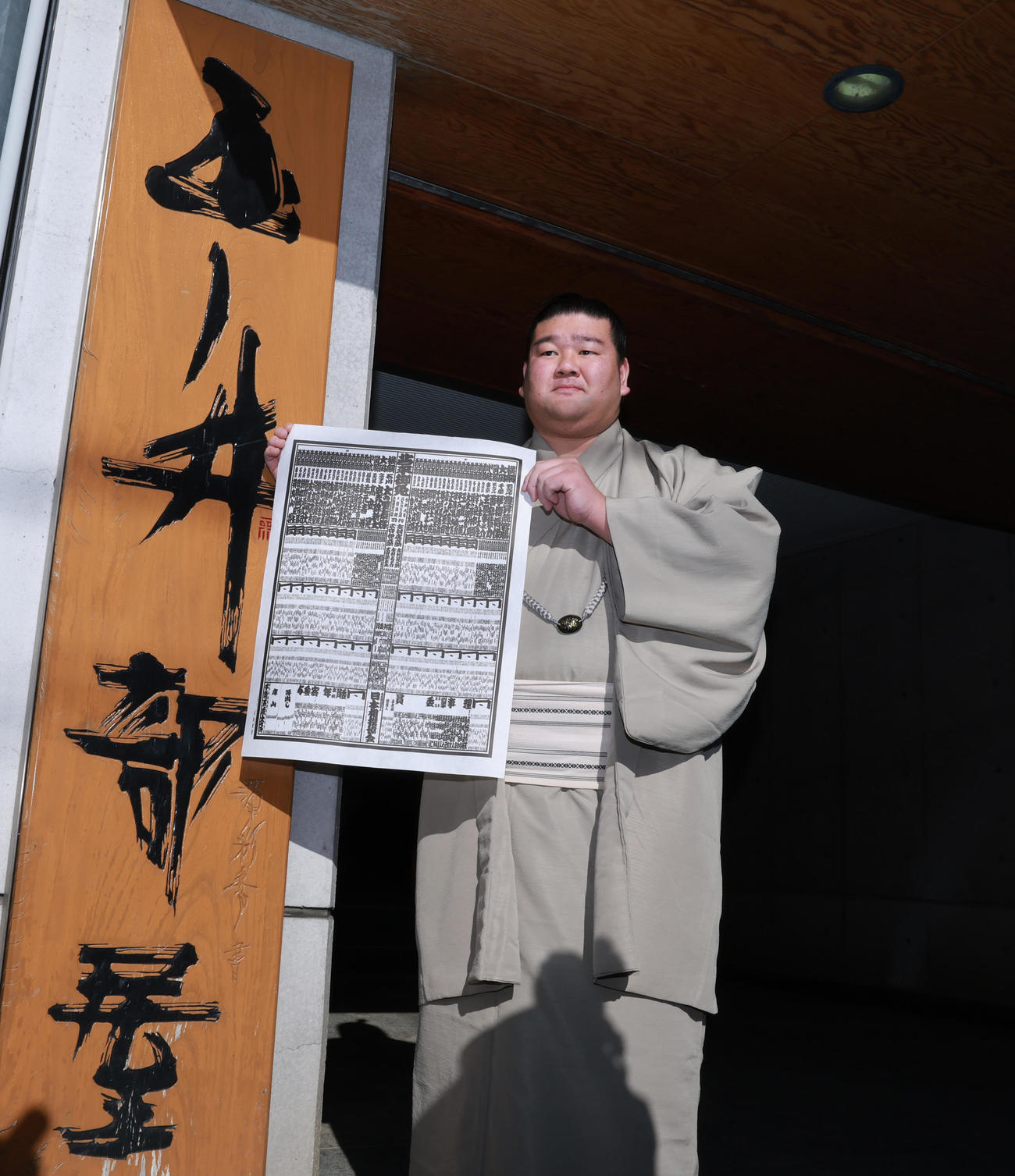 初場所での新入幕を決め、番付表を手にする羽出山（撮影・野上伸悟）