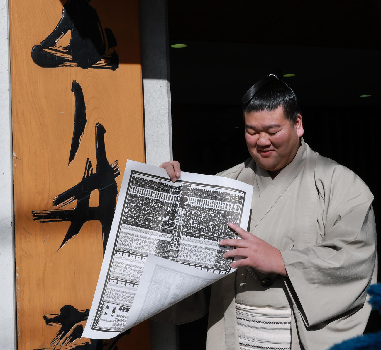初場所での新入幕を決め、番付表を手にする羽出山（撮影・野上伸悟）
