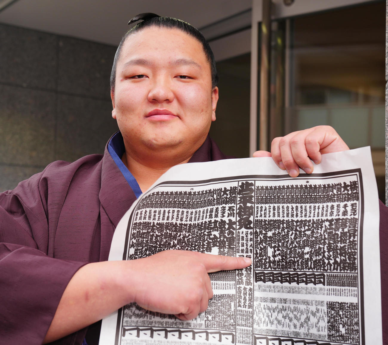 新入幕の朝白龍は番付表を手に写真に納まる（撮影・垰建太）