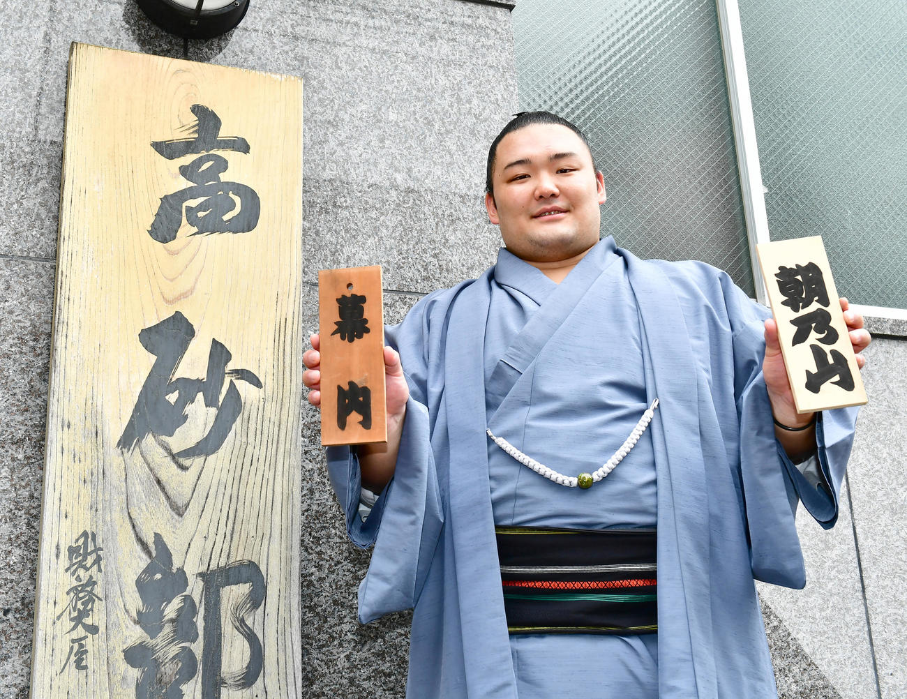 17年、9月場所での新入幕入りを果たし、自らのしこ名と幕内と書かれた木札を手に笑顔を見せる朝乃山