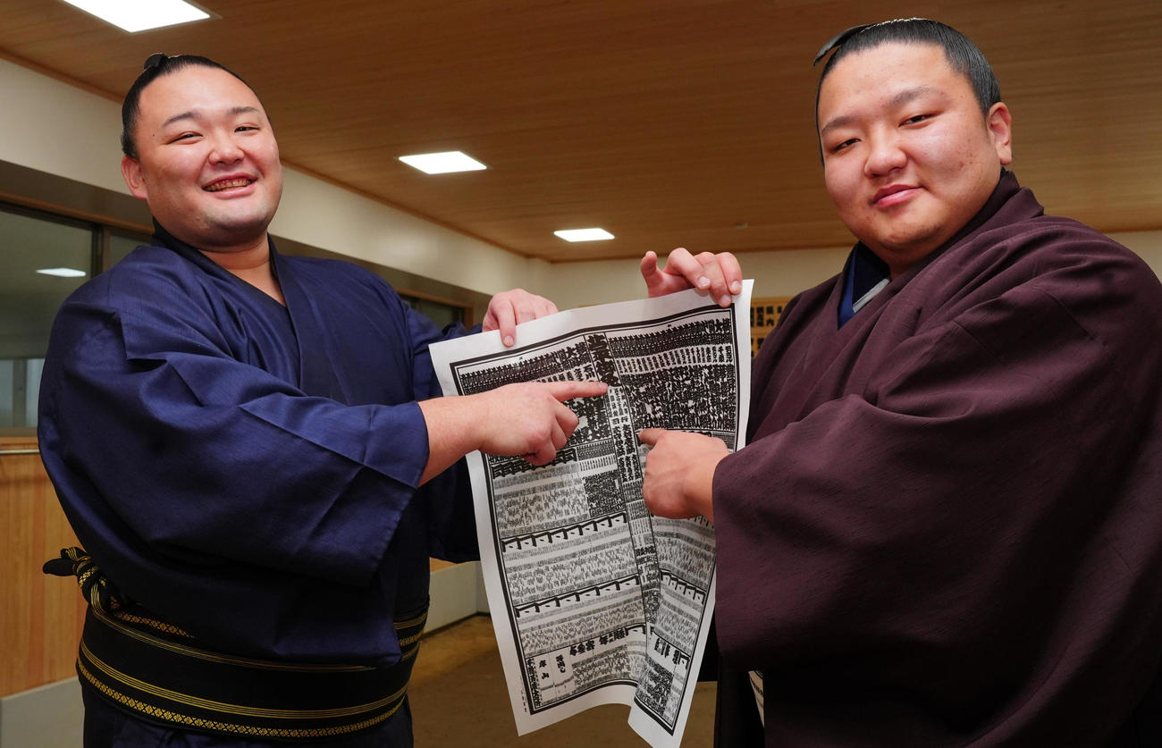 新入幕の朝白龍（右）は再入幕の朝乃山と番付表を手に笑顔で写真に納まる（撮影・垰建太）