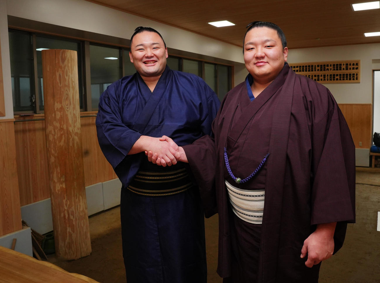 再入幕の朝乃山（左）は新入幕の朝白龍と握手を交わし笑顔で写真に納まる（撮影・垰建太）