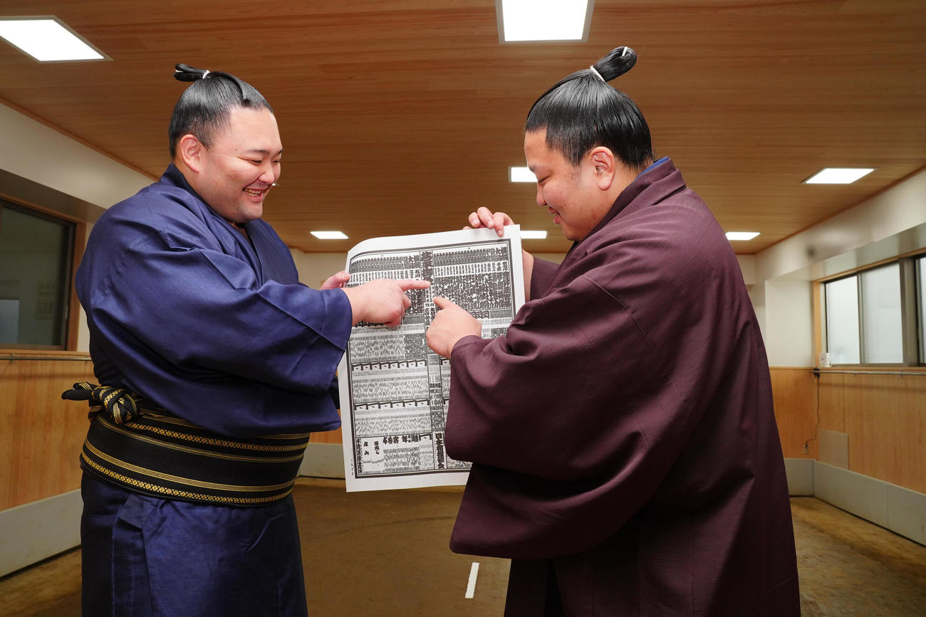 再入幕の朝乃山（左）は新入幕の朝白龍と番付表を笑顔で見つめる（撮影・垰建太）
