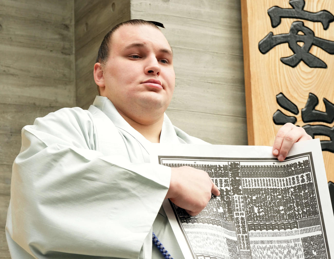番付を手に記念撮影に納まる新大関安青錦（撮影・たえ見朱実）