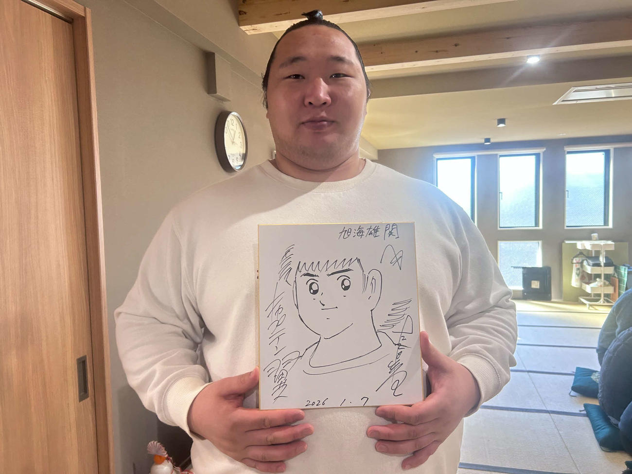 初場所でキャプテン翼の化粧まわしを締める返り十両の旭海雄は、作者の高橋陽一先生からサイン色紙をもらった(撮影・平山連)