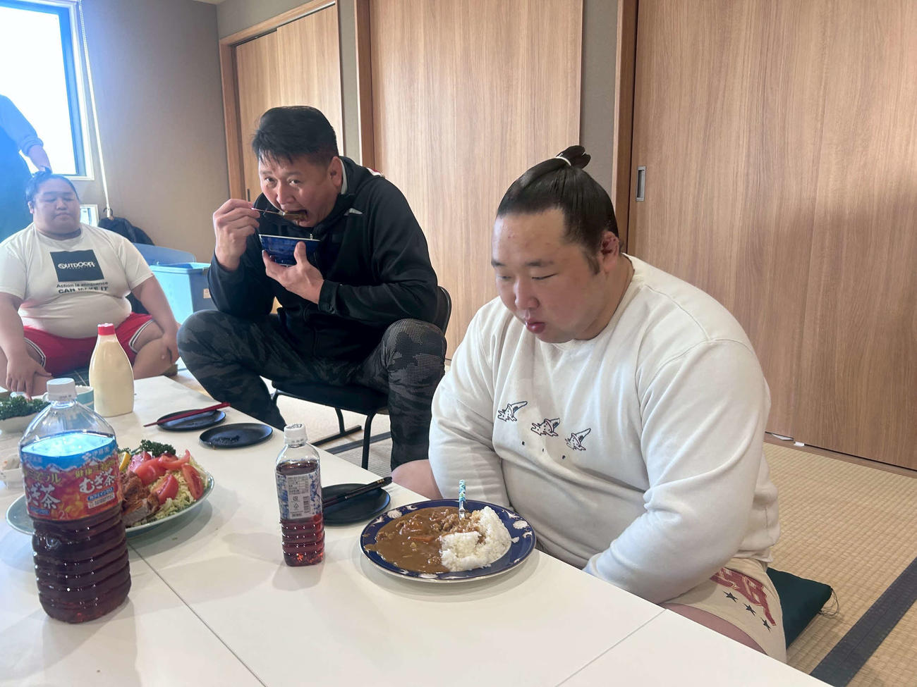 大島部屋の勝負飯「パパカツカレー」を食べる部屋頭の十両・旭海雄（右）と師匠の大島親方(撮影・平山連)
