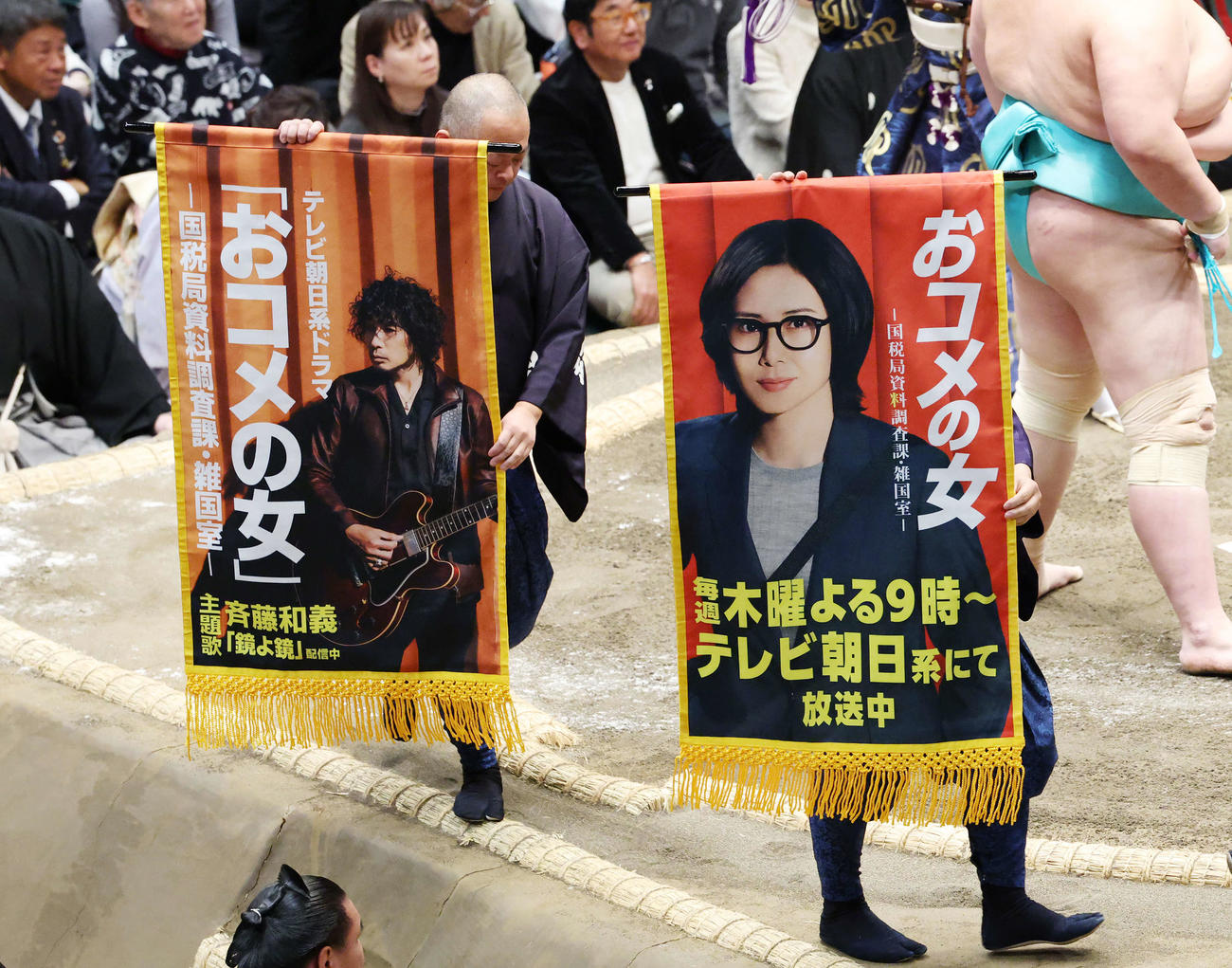 琴桜と義ノ富士の一番で土俵をまわるテレビ朝日新ドラマ「おコメの女」の懸賞幕（撮影・宮地輝）