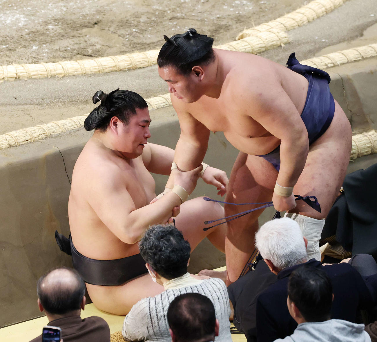 寄り倒しで破った若元春（左）に手を貸す豊昇龍（撮影・宮地輝）