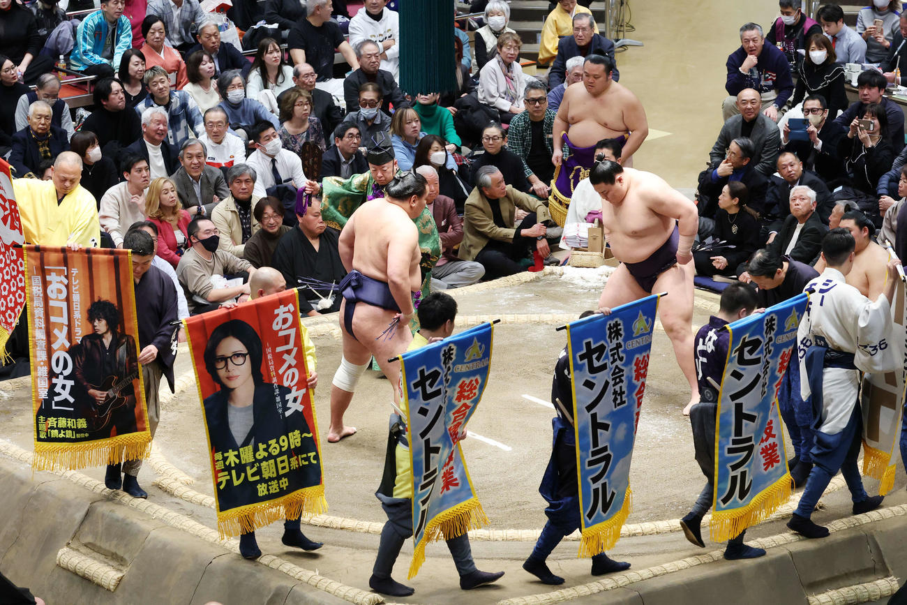 豊昇龍と義ノ富士の一番で土俵をまわるテレビ朝日新ドラマ「おコメの女」の懸賞幕を見つめる高橋克実（撮影・宮地輝）