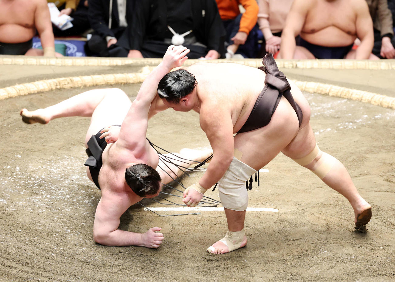 獅司（左）をすくい投げで破る朝乃山（撮影・鈴木正人）