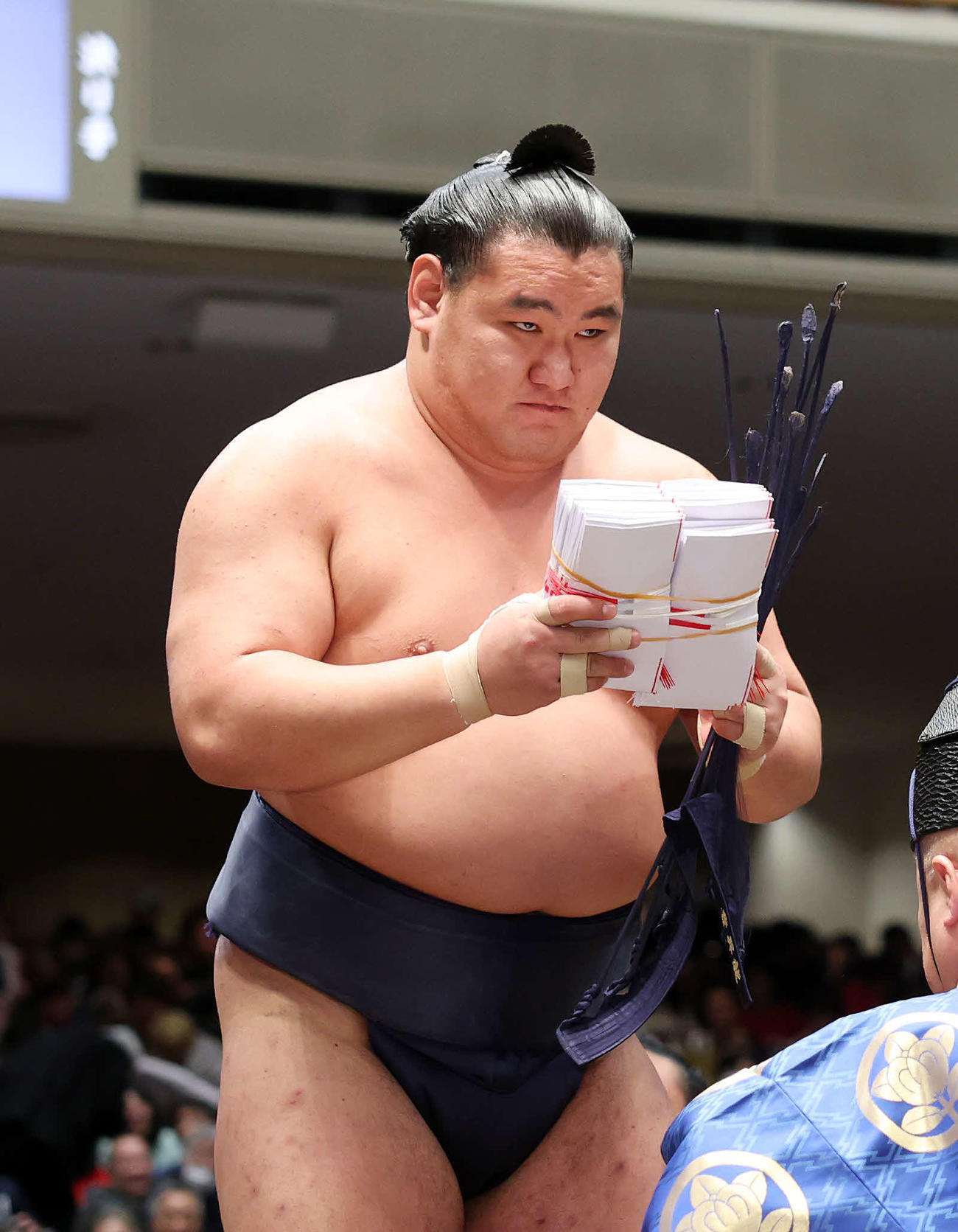 懸賞金の束を手に土俵を引き揚げる豊昇龍（撮影・鈴木正人）