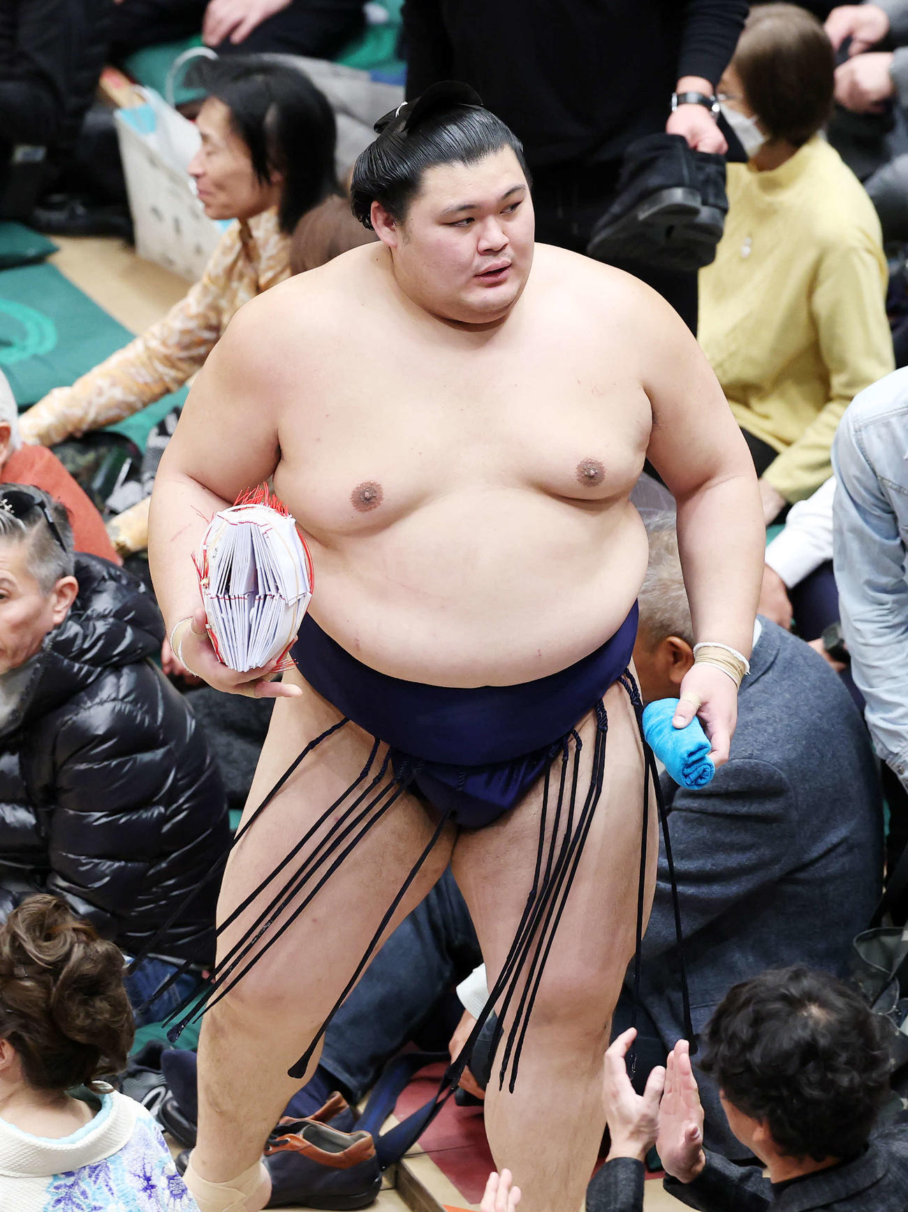 懸賞金の束を手に土俵を引き揚げる大の里（撮影・鈴木正人）