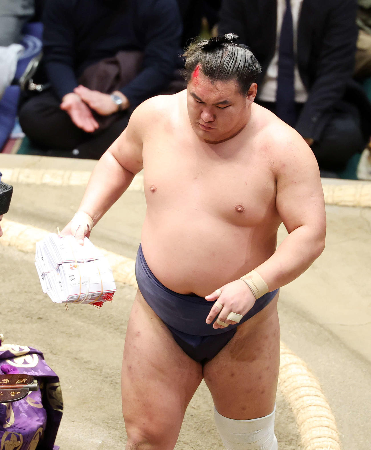 懸賞金の束を手に土俵を引き揚げる豊昇龍（撮影・鈴木正人）
