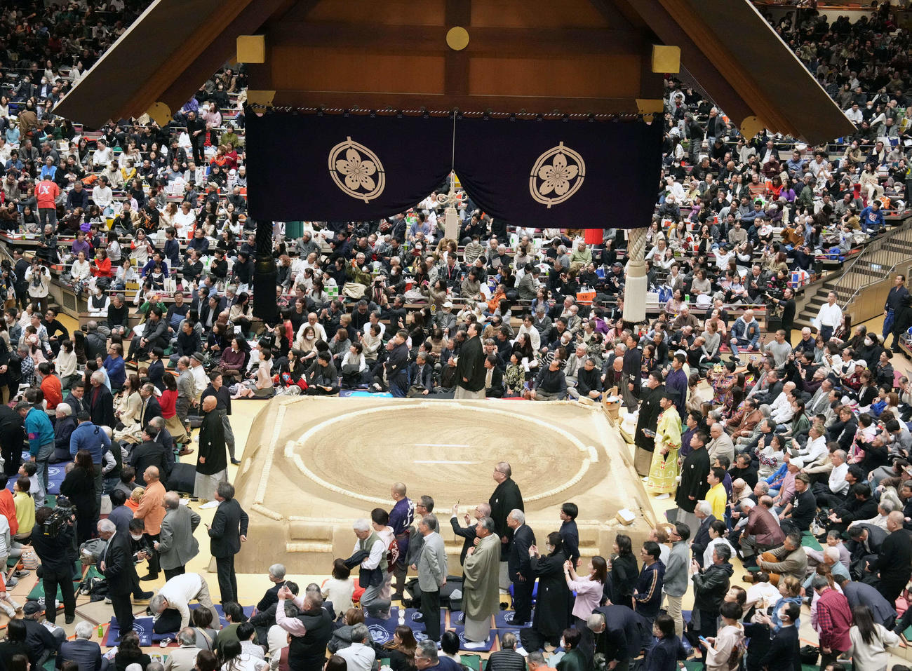 天皇皇后両陛下の到着を待ち総立ちする審判や詰め掛けた観客たち（撮影・小沢裕）