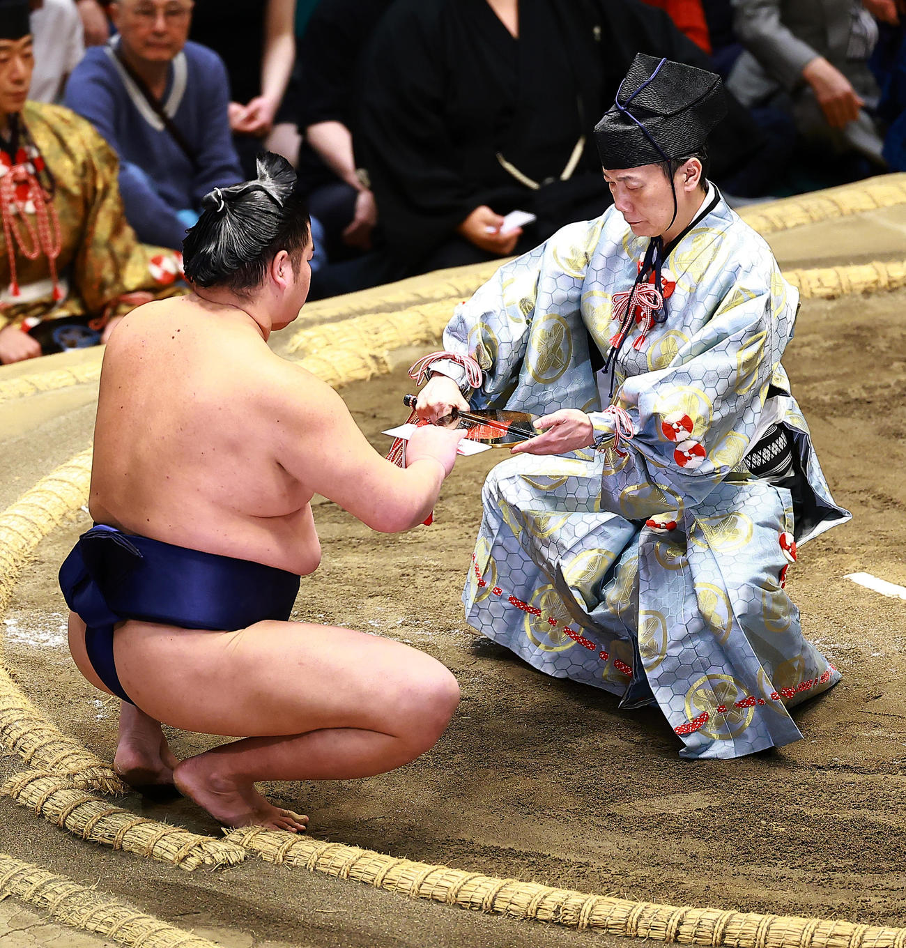 友風を押し出しで破り初白星を上げ、懸賞金を受けとる羽出山（撮影・野上伸悟）