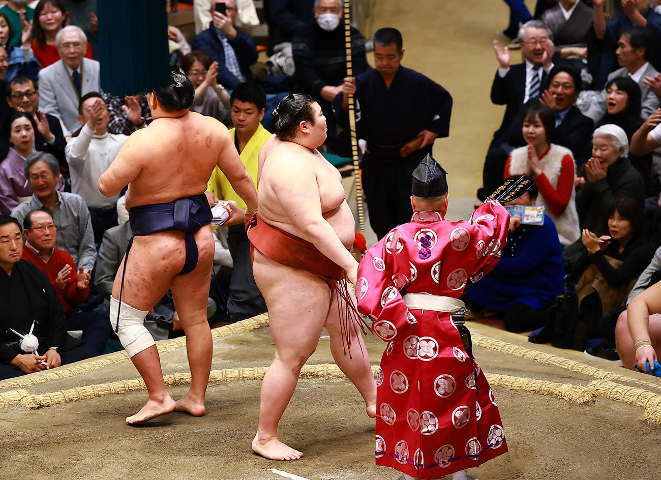 豊昇龍（左）を押し出しで破った熱海富士。後方右上は青学大・原監督夫妻（撮影・野上伸悟）