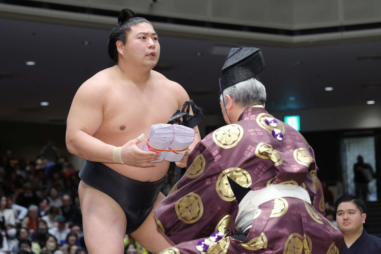 大の里を寄り切りで下し、懸賞金の束を手にする若元春（撮影・河田真司）