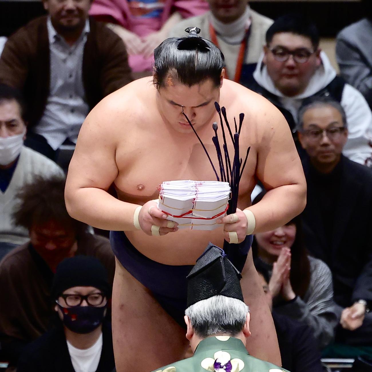 王鵬を上手出し投げで破り、懸賞金の束を手にする豊昇龍（撮影・河田真司）